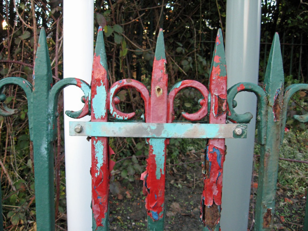 Section of old railing with peeling paint, several colours/layers