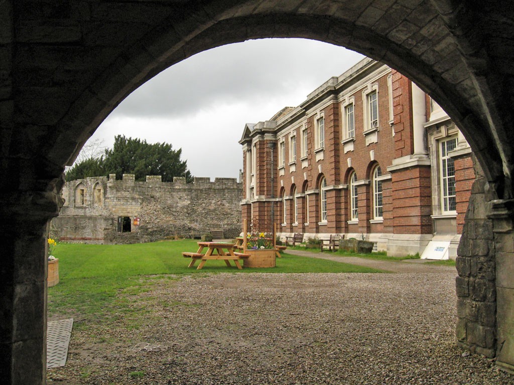 Buildings and grassed area framed by arch