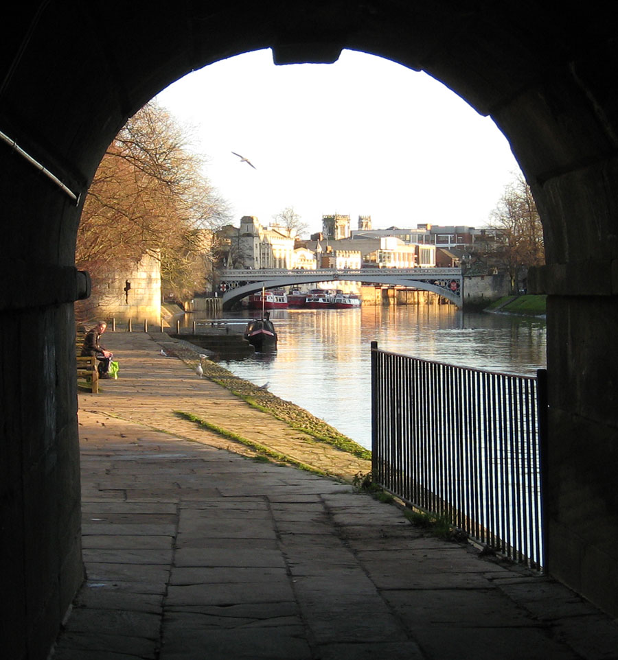 Archway framing sunlit river scene