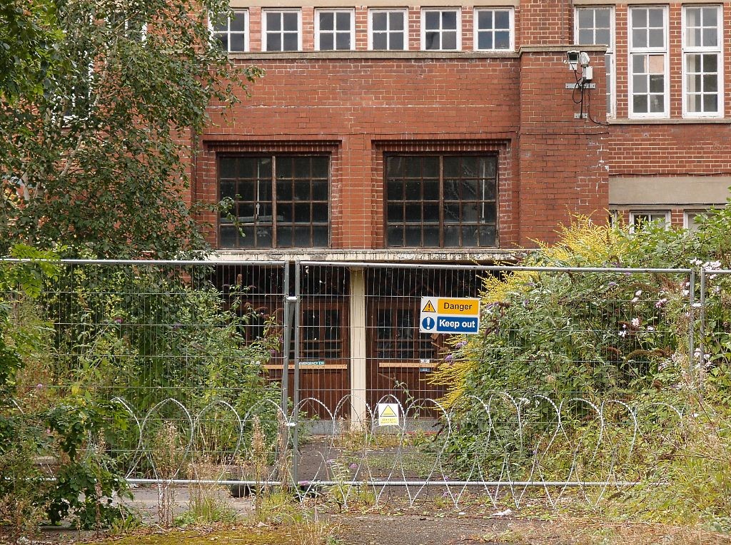 Closer view: former factory entrance, and razor wire, Sept 2016