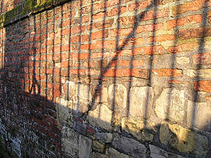 Sunlight through railings, on red brick and stone