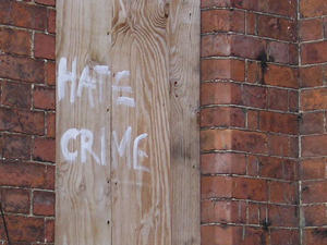 Slogan  'Hate Crime' on boarded-up window